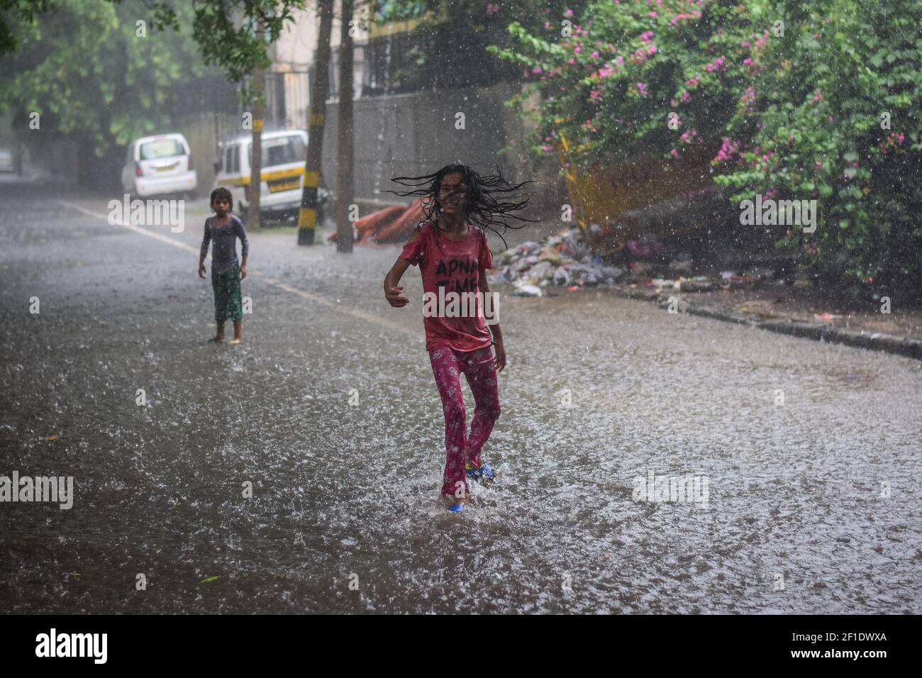Los niños vieron jugar bajo la lluvia, durante las fuertes lluvias en Delhi. La lluvia intensa golpea partes de Delhi y es probable que esta semana se produzcan más lluvias. (Foto de Manish Rajput / SOPA Images/Sipa USA) Foto de stock