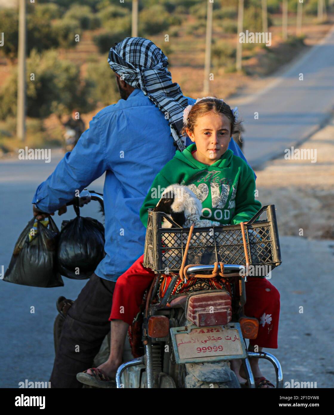 Una niña pequeña vio llevar una oveja mientras ella viaja con su padre en una motocicleta. (Foto de Fadi al-Shami / SOPA Images/Sipa USA) Foto de stock