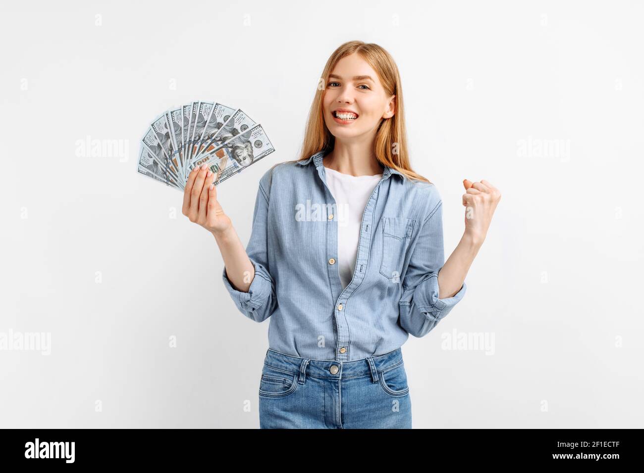 Retrato de una joven alegre con billetes de dinero y celebrando aislado sobre fondo blanco Foto de stock