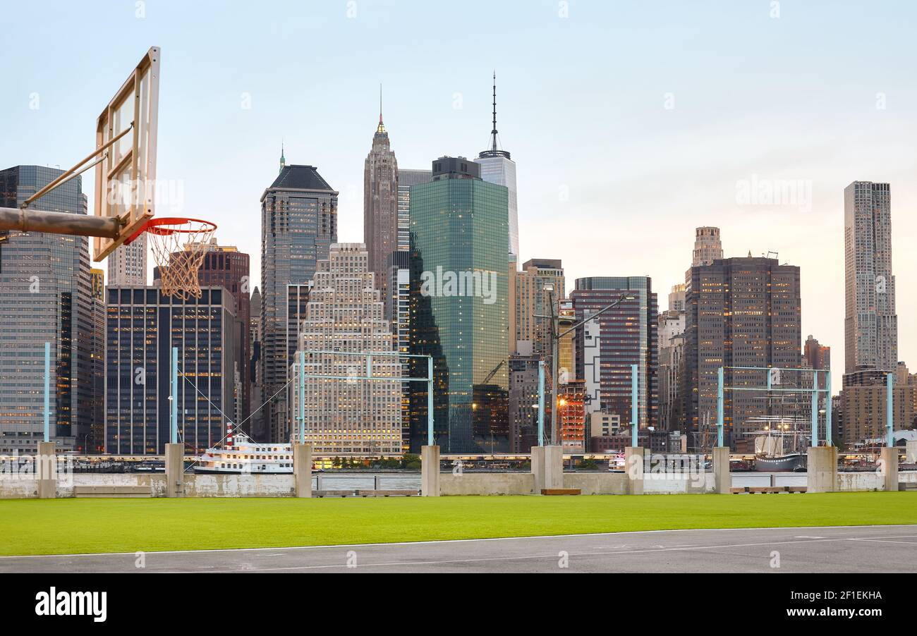 Manhattan horizonte visto desde la cancha deportiva al atardecer, foco en el fondo, EE.UU.. Foto de stock