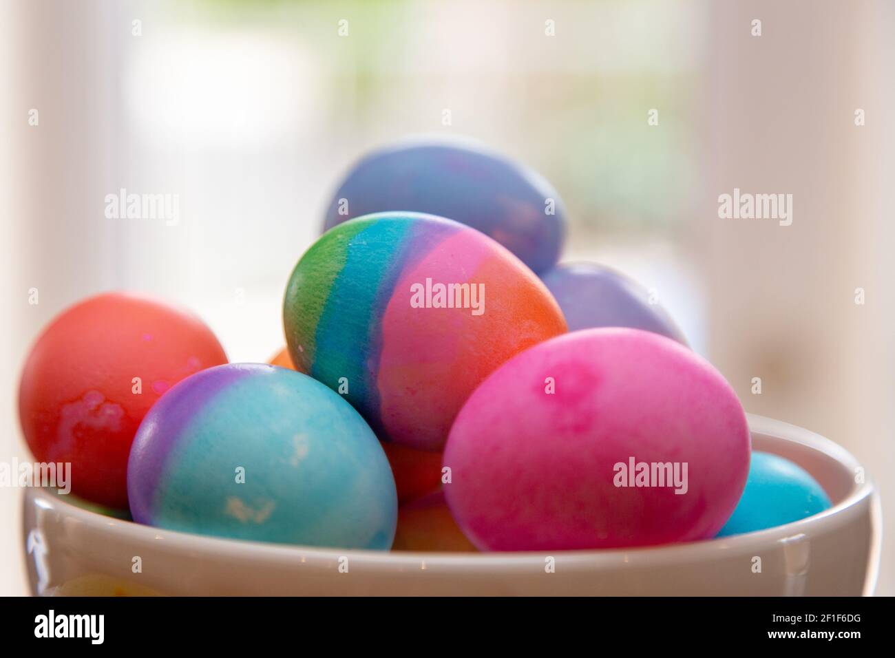 Primer plato de huevos de Pascua de colores brillantes en juego Foto de stock
