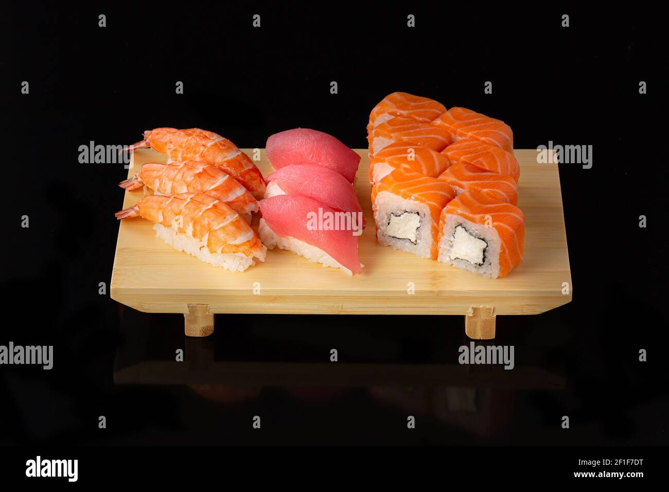 Set de sushi. Rollos con caviar rojo de anguila de salmón y verduras sobre fondo negro. Foto de stock