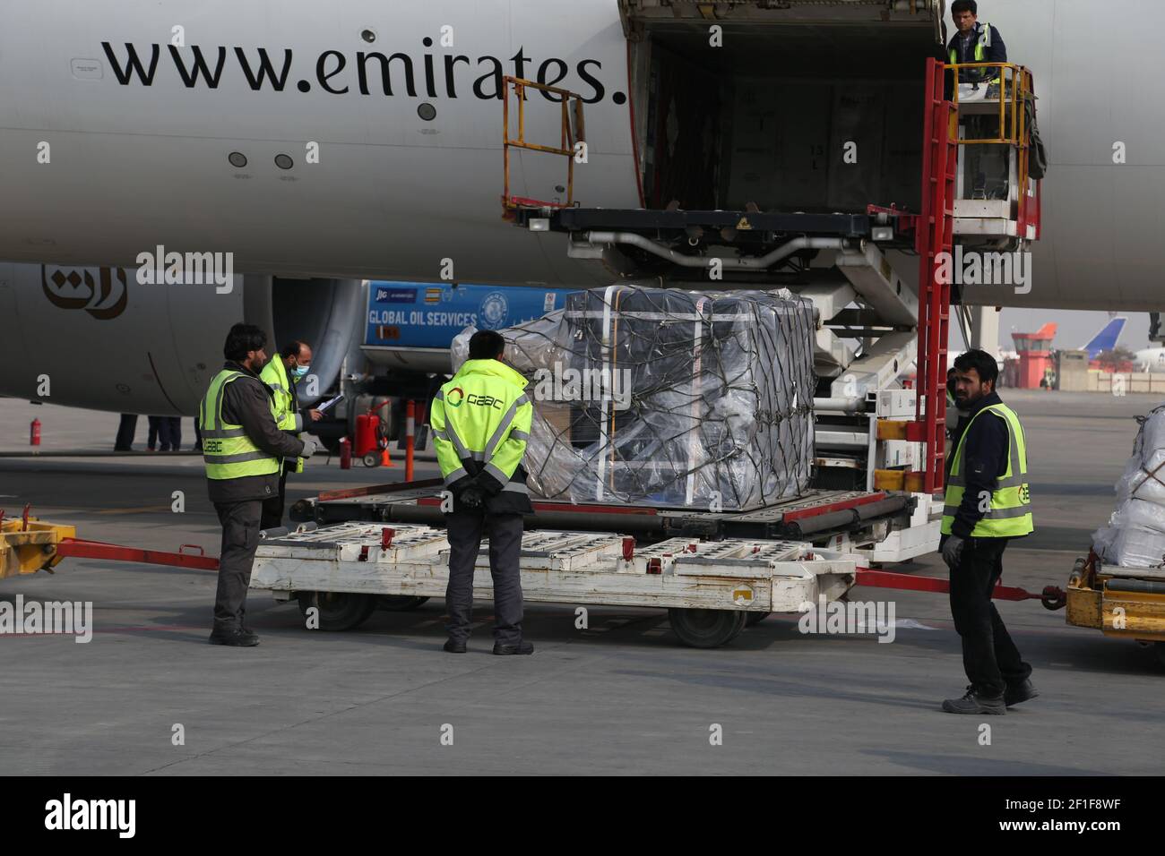 Kabul, Afganistán. 8th de marzo de 2021. Los trabajadores del aeropuerto descargan las vacunas COVID-19 de COVAX, un programa internacional diseñado para ayudar a los países de ingresos bajos y medianos a tener más acceso a las vacunas COVID-19, en el Aeropuerto Internacional Hamid Karzai en Kabul, capital de Afganistán, el 8 de marzo de 2021. Crédito: Sayed Mominzadah/Xinhua/Alamy Live News Foto de stock