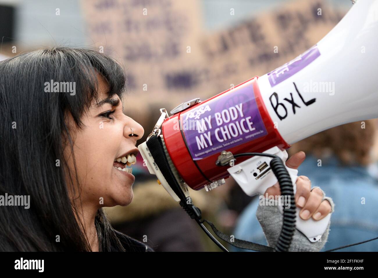 Una mujer utiliza un megáfono durante una manifestación para conmemorar el día Internacional de la Mujer en Bruselas, Bélgica, el 8 de marzo de 2021. La pegatina dice "Mi cuerpo, Mi elección". REUTERS/Johanna Geron Foto de stock