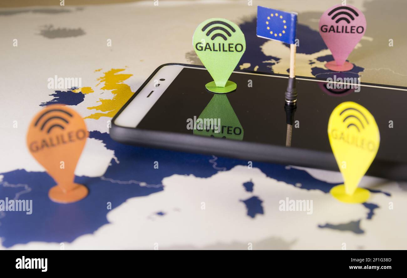 Coche de juguete, pin Galileo y un smartphone sobre un mapa de la UE.  Metáfora del sistema Galileo Fotografía de stock - Alamy