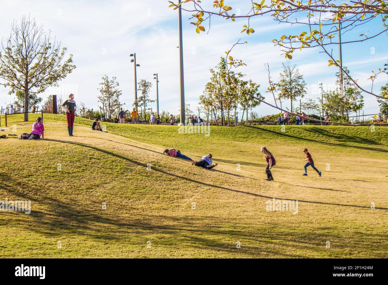 10-21-2018-Tulsa USA - los niños que bajan una colina de hierba Parque público urbano único - el lugar de encuentro - en Oklahoma - movimiento borroso Foto de stock