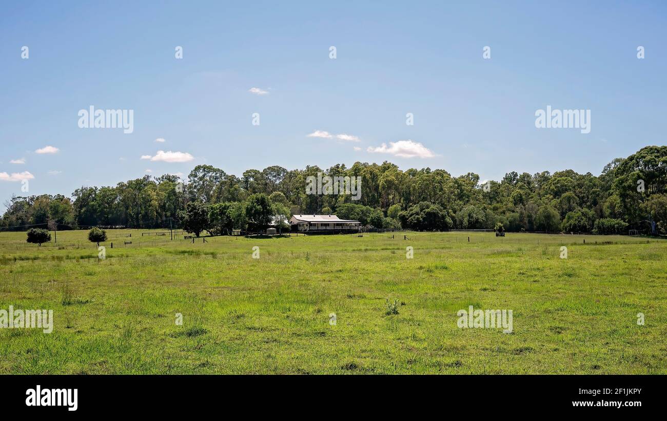 Una hacienda rural en hectáreas de campos verdes Foto de stock
