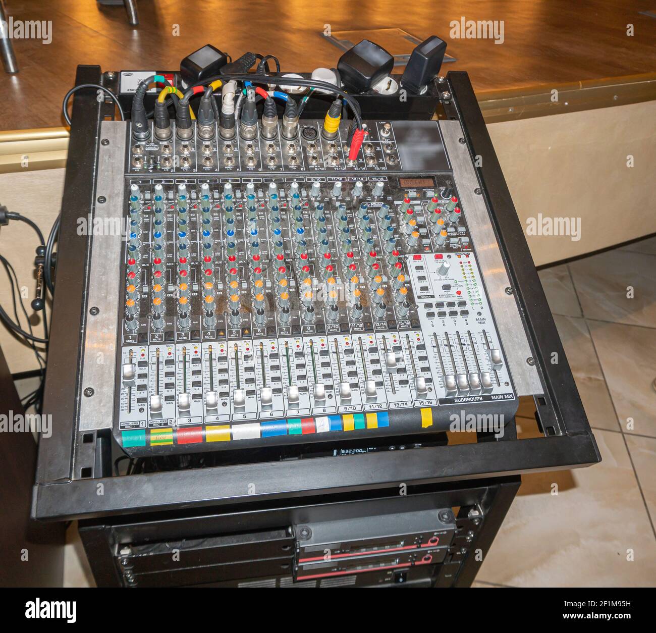 Consola de ingeniería de sonido con enchufes y dispositivos de sonido conectados una sala de conciertos Foto de stock
