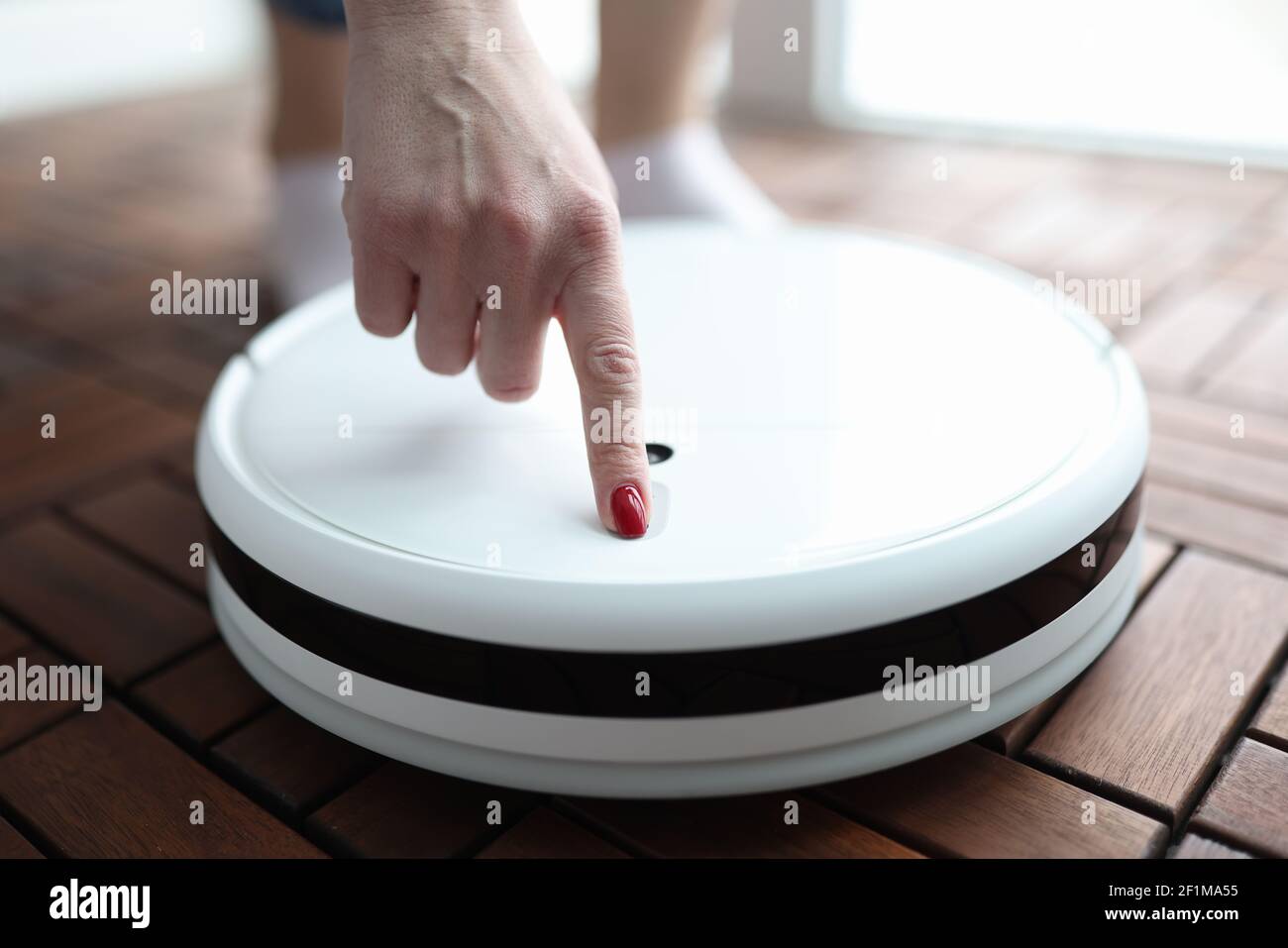 Mujer pulsando el botón en robot aspirador primer plano Fotografía de stock  - Alamy