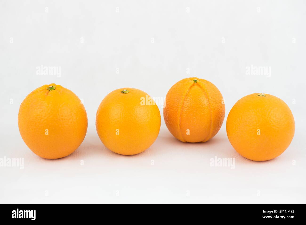 Cuatro naranjas, una de las cuales es defectuosa (ilustración de singularidad, desigualdad) Foto de stock