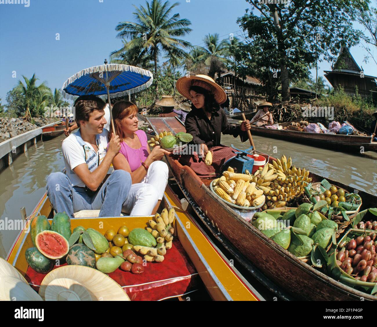 Tailandia. Bangkok. Mercado flotante. Turistas con vendedor de frutas. Foto de stock