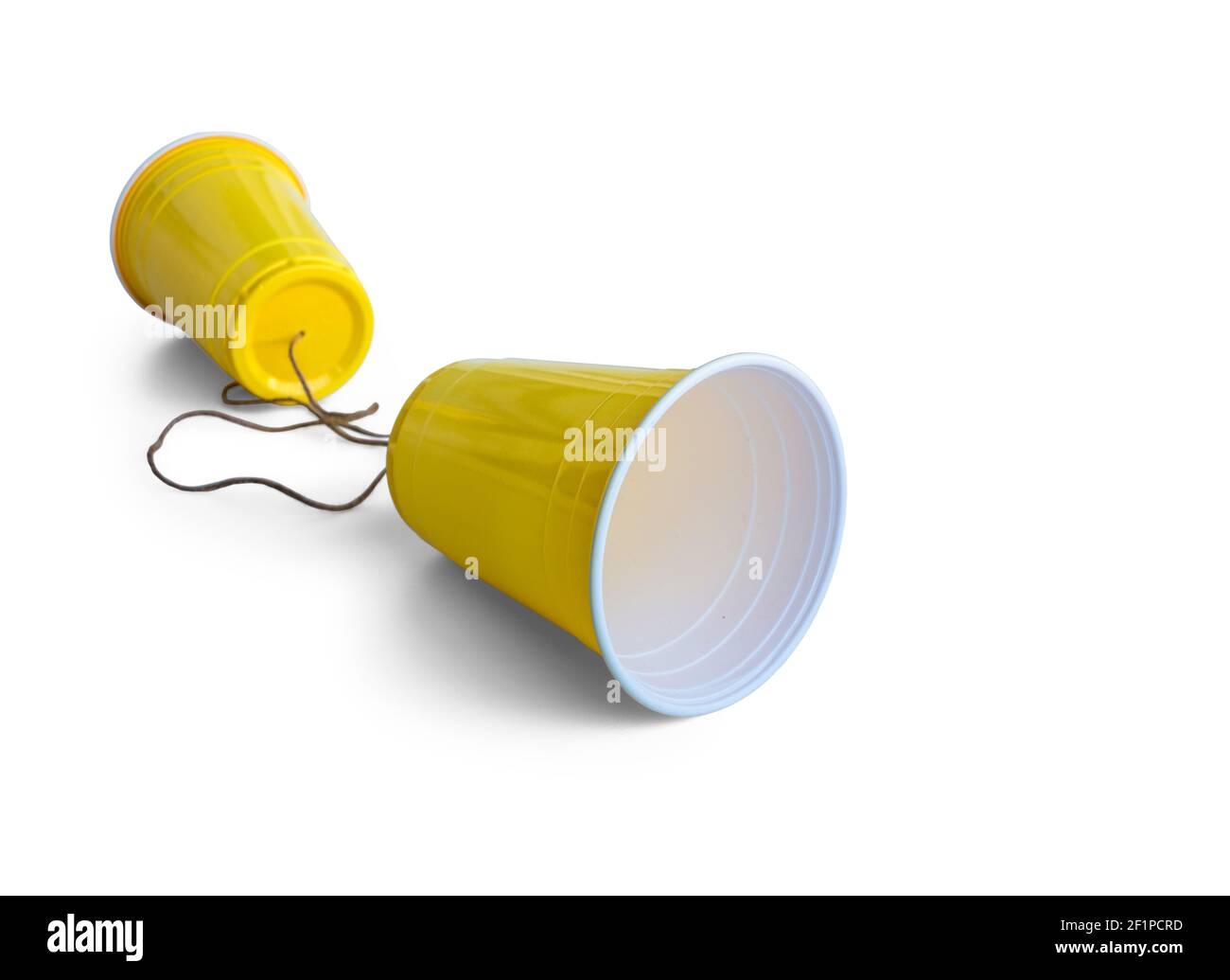 Comunicación Copa de plástico amarilla con cuerda aislada sobre fondo blanco Foto de stock