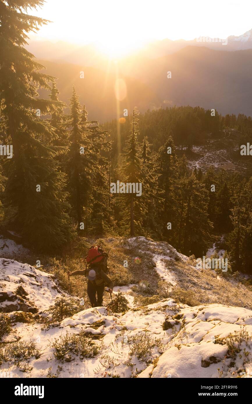 Mochileros caminatas por la montaña durante la puesta de sol. Foto de stock