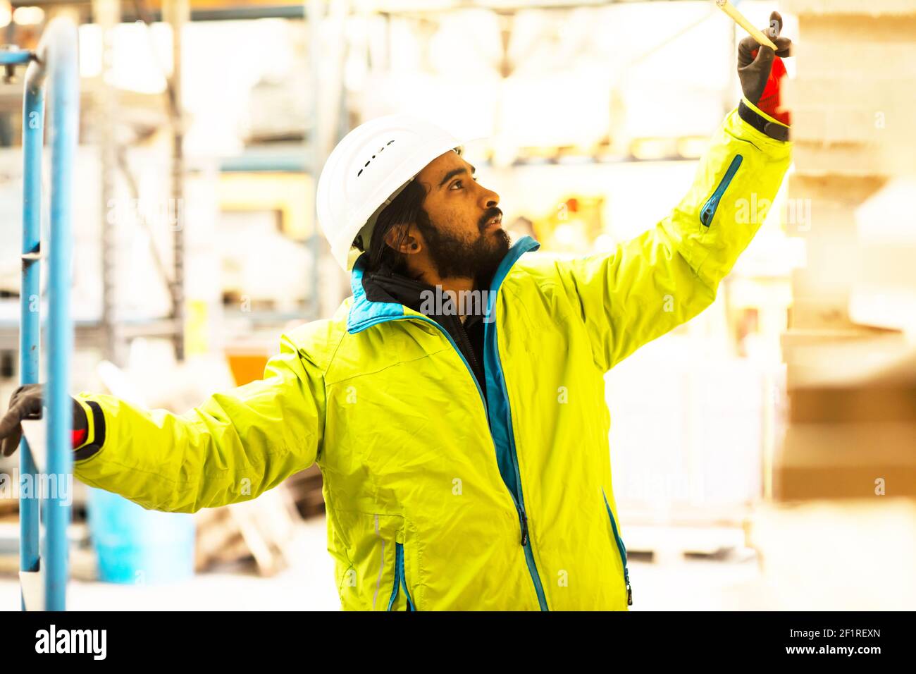 Un hombre con barba, casco y ropa de trabajo. retrato de un