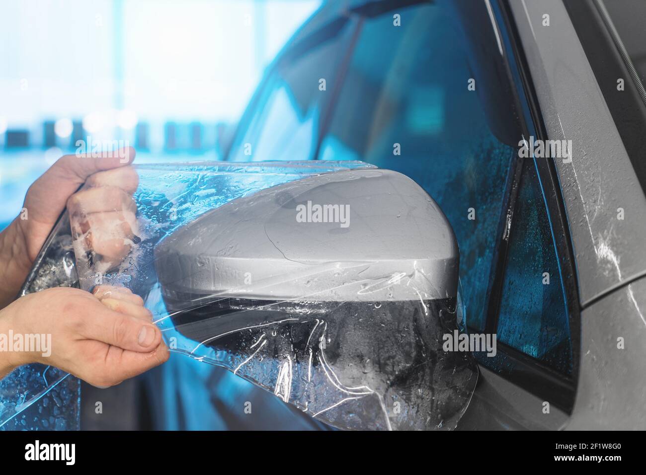 Instalación de PPF en el espejo lateral del coche. La película de  protección de pintura es un recubrimiento protector de poliuretano para la  pintura en el coche Fotografía de stock - Alamy