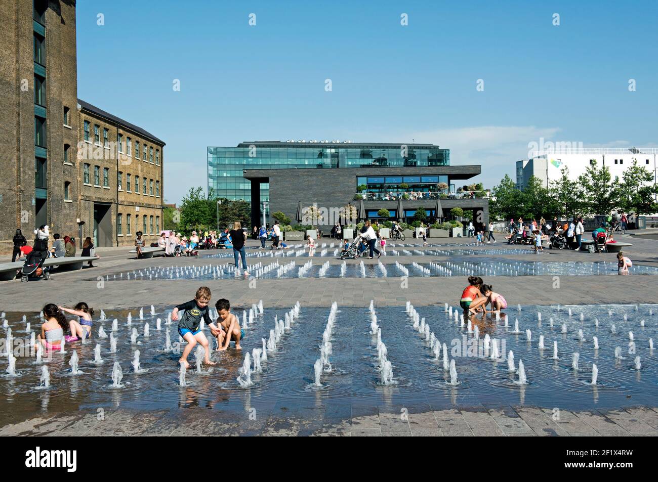 Niños jugando en fuentes de agua, Granary Square, Kings Cross Foto de stock