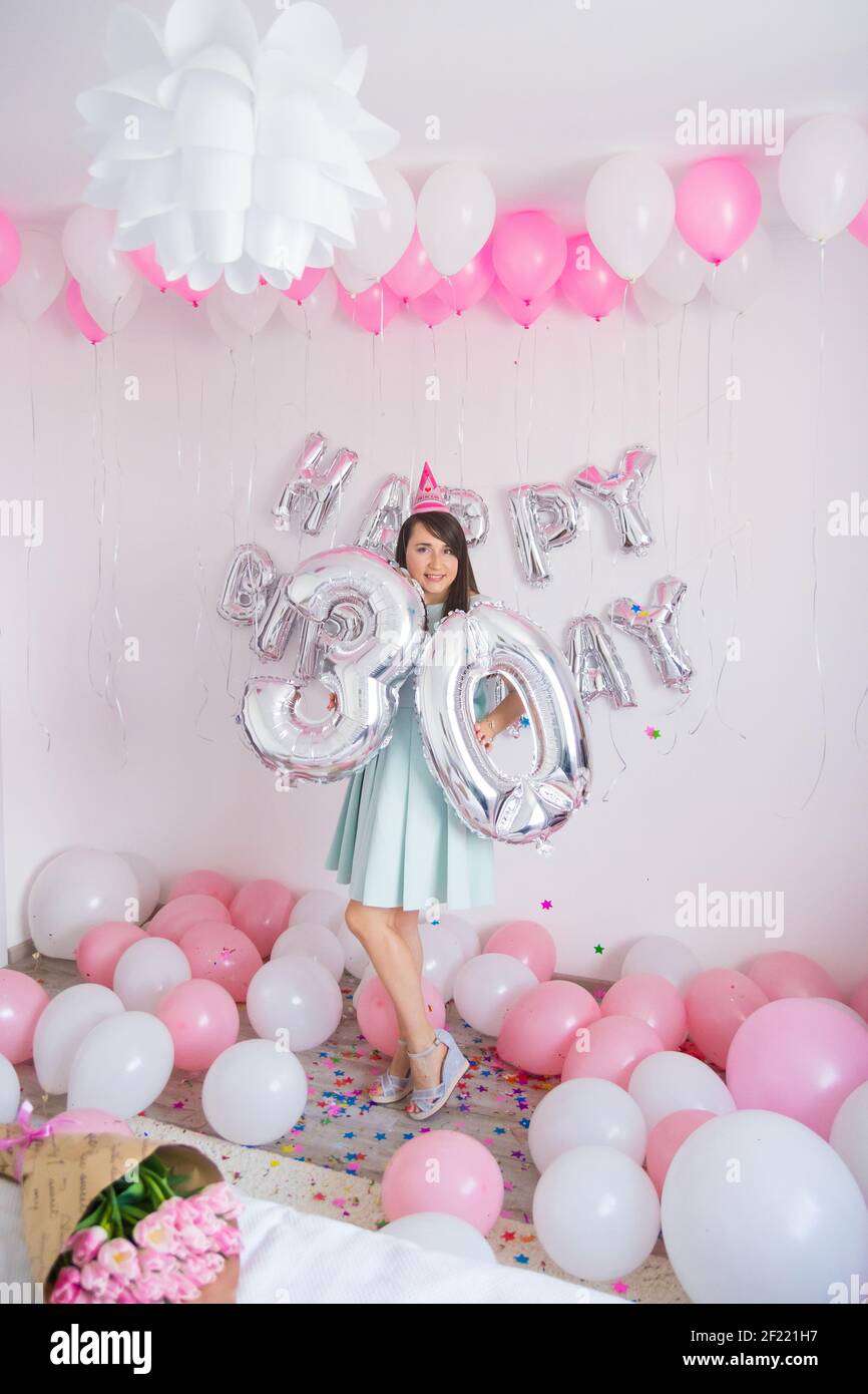 Mujer de pie en decoraciones con globos y confeti para el cumpleaños fiesta  Fotografía de stock - Alamy