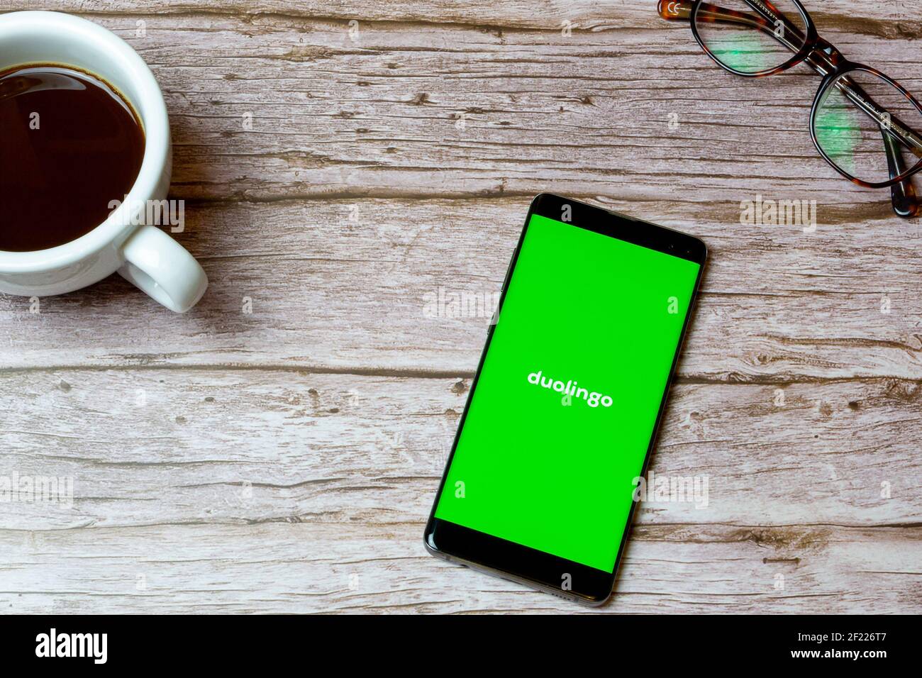 Un teléfono móvil o celular colocado sobre una mesa O escritorio con la  aplicación Duolingo abierto y un café al lado Fotografía de stock - Alamy