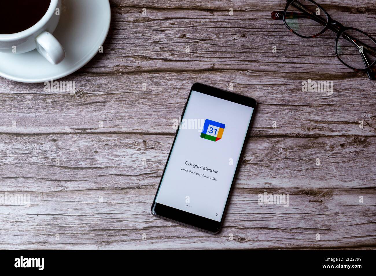 0A teléfono móvil o teléfono celular colocado sobre una madera Mesa o  escritorio con la aplicación Google Calendar abierta Fotografía de stock -  Alamy