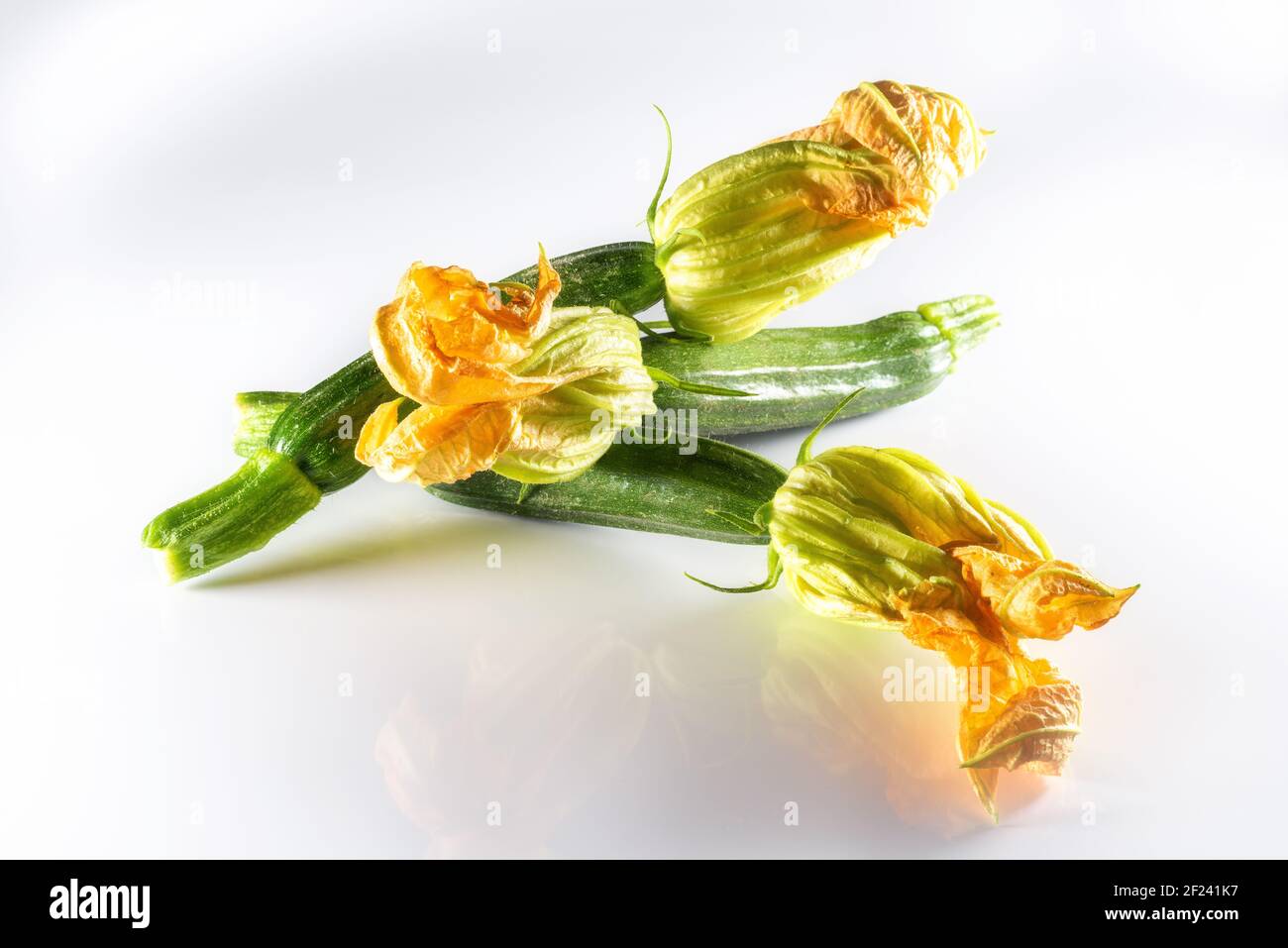 Calabacín con flores sobre fondo blanco. Concepto de verduras de temporada. Foto de stock