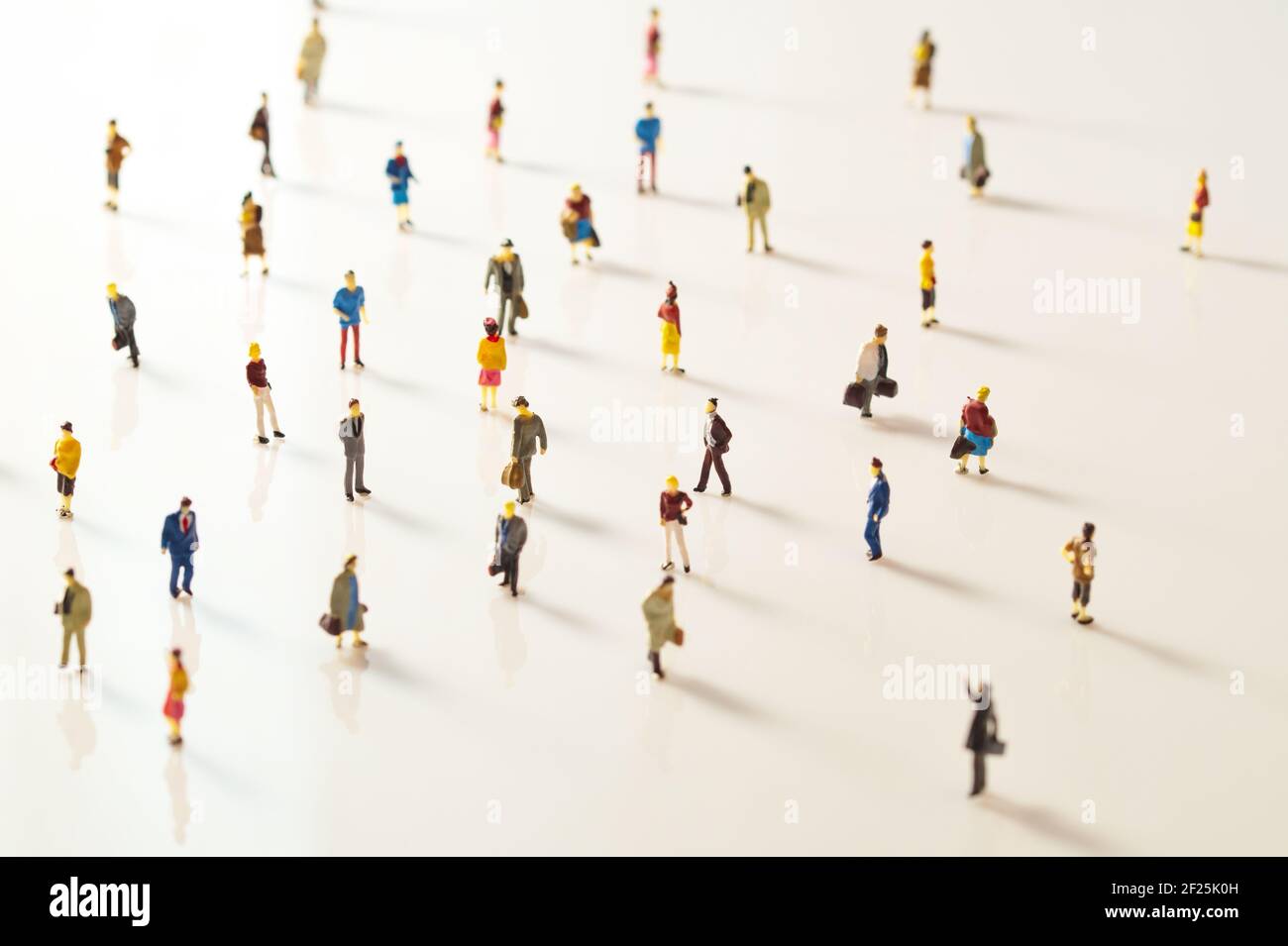 Gente de juguete, figurillas en miniatura manteniendo la distancia en público. Distanciamiento social debido al Covid-19 Foto de stock
