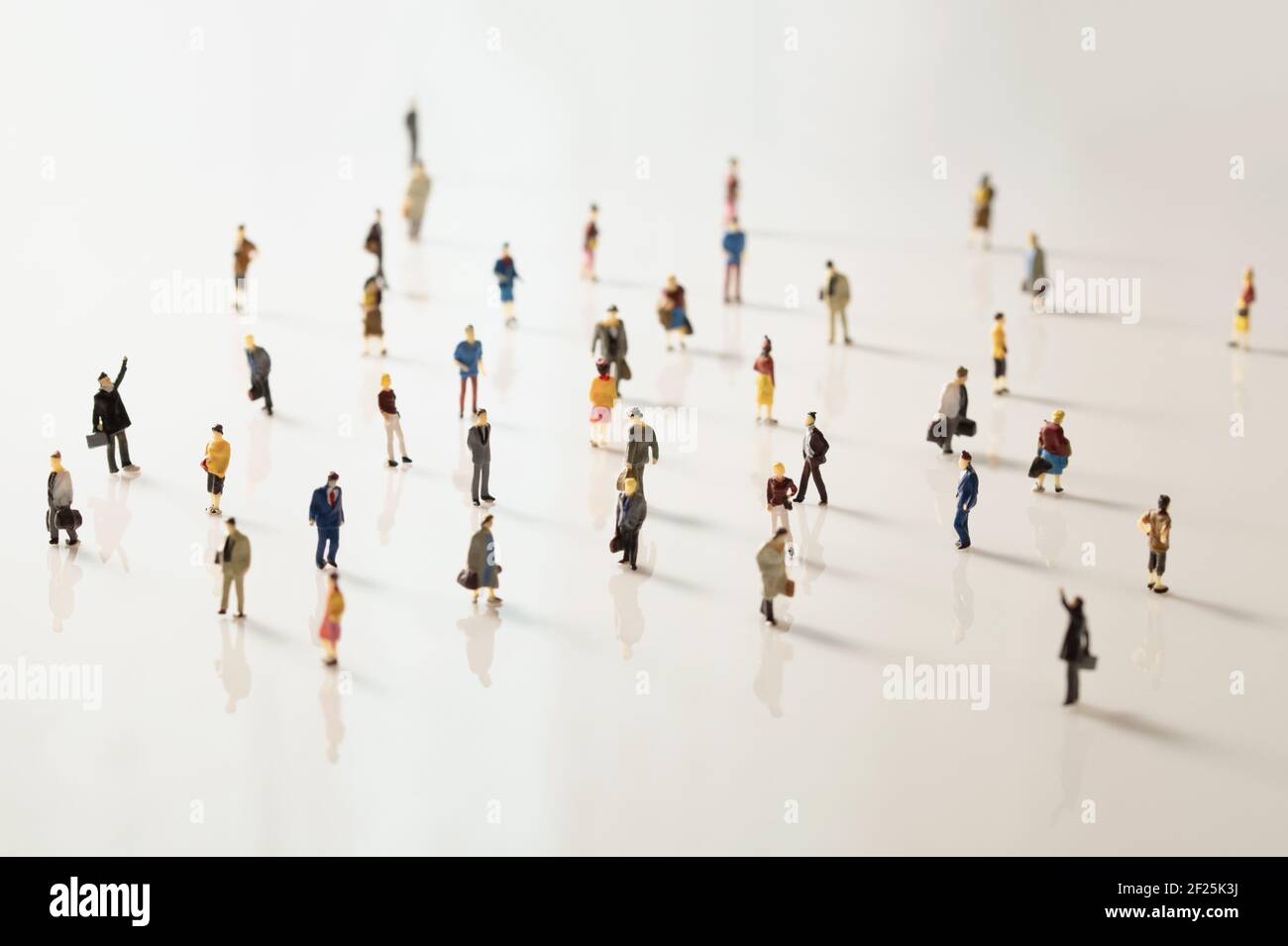 Miniatura juguete gente mantener la distancia en público. Distanciamiento social debido al brote de Covid-19 Foto de stock