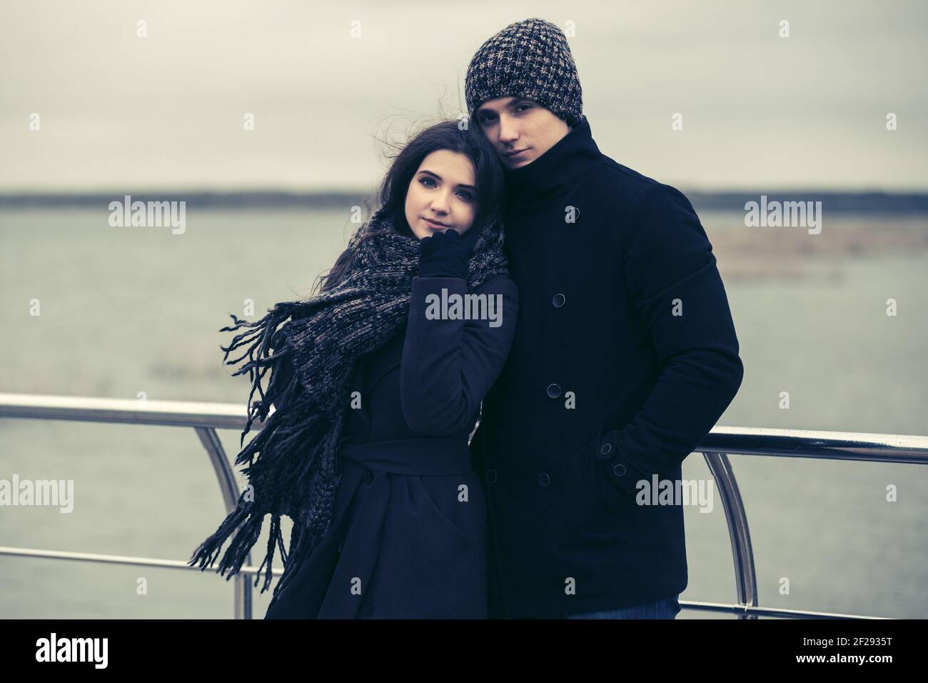 Feliz joven pareja de moda en el amor con estilo hombre y mujer en clásicos abrigos gorro bufanda Fotografía de - Alamy