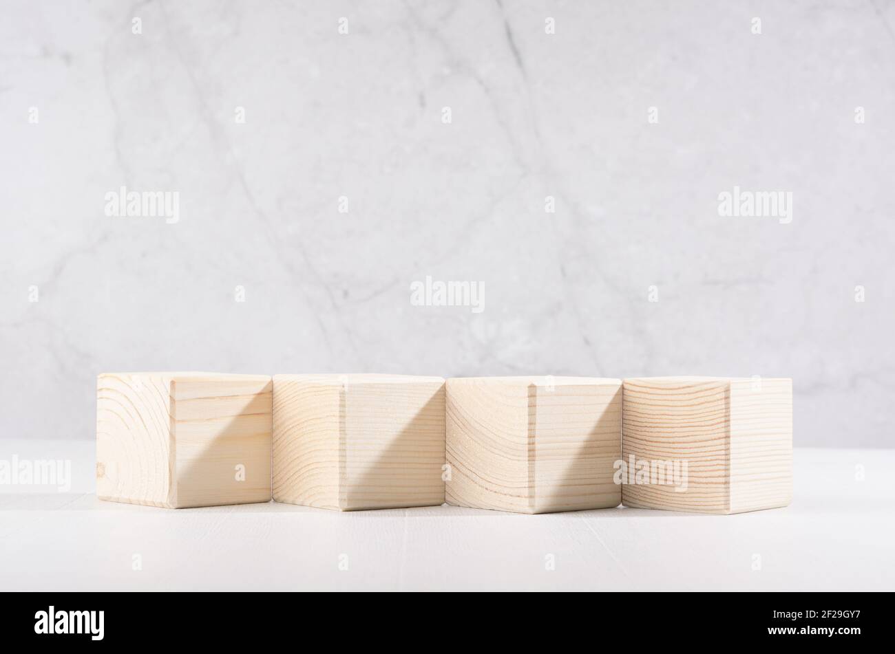 Podios de madera beige de cubos en fila en el interior de color blanco  claro suave con pared de mármol, vista frontal, para la exposición y  presentación de productos, cosméticos Fotografía de