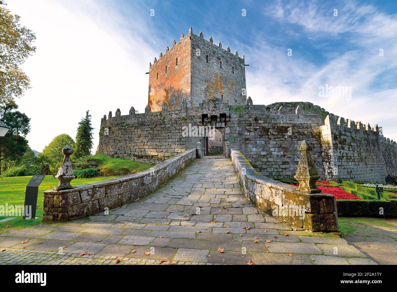 Entrada principal del impresionante castillo medieval con torre y jardines alrededor Foto de stock