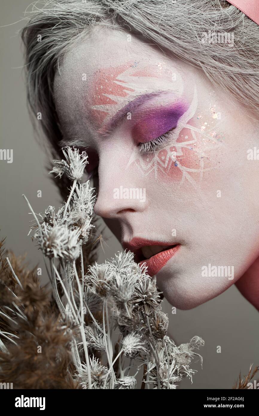 Hermosa mujer de invierno con maquillaje de copos de nieve en su cara y  flores secas, primer plano retrato Fotografía de stock - Alamy