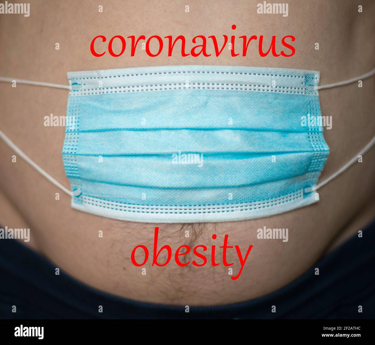 Máscara médica azul en el estómago del hombre, el hombre ganando peso durante la pandemia de la crisis del coronavirus. Concepto de obesidad Foto de stock