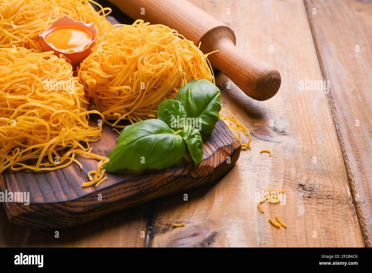 La pasta tagliatelle es fina. Tradicional italiano llamado Angel Hair. Pasta de huevo italiana, casera y fresca sobre una mesa de madera. Cocina rústica del norte de Italia. Espacio de copia Foto de stock