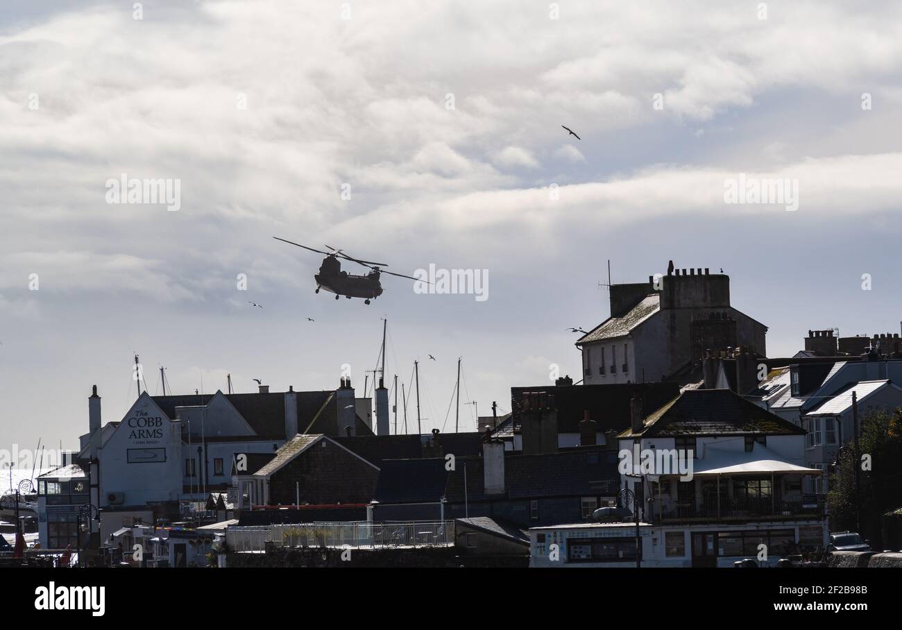 Lyme Regis, Dorset, Reino Unido. 11th de marzo de 2021. Reino Unido Clima: Un helicóptero Chinook vuela bajo sobre la costa en Lyme Regis en un día ventoso con fuertes lluvias e intervalos soleados. Pronóstico del tiempo más inestable en todo el suroeste. Crédito: Celia McMahon/Alamy Live News. Foto de stock