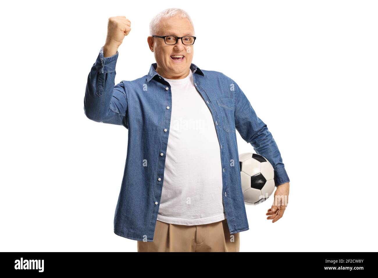 Feliz hombre maduro sosteniendo un balón de fútbol y gestando con aislado a mano sobre fondo blanco Foto de stock