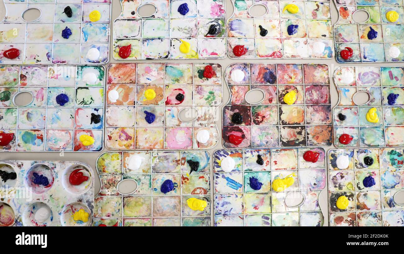 Un arreglo de paletas de pintura preparado para la clase de arte en la escuela. Colores primarios y secundarios organizados en una bandeja creativa Foto de stock