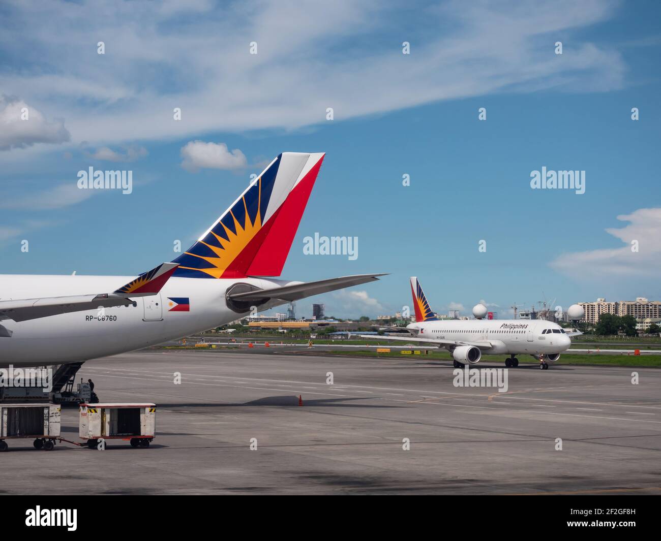 Avión de cola de Philippine Airlines Airbus A330 en la Terminal 2 del Aeropuerto Internacional Ninoy Aquino en Manila, con Philippines Airlines Airbus A320 en t. Foto de stock