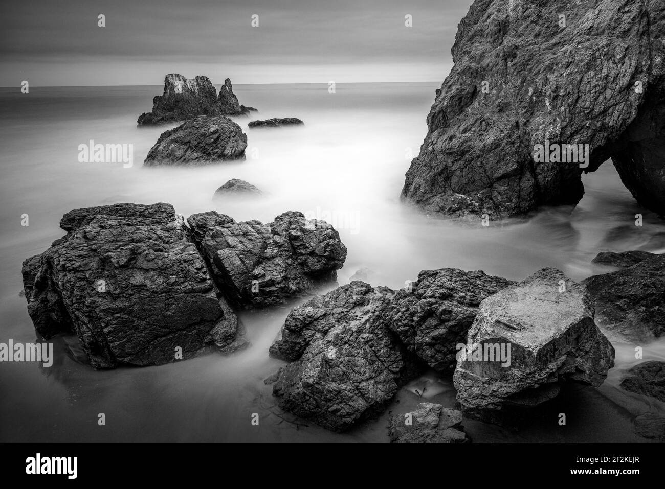 Larga exposición de el Matador State Beach puesta de sol con la roca en el primer plano y las olas rompiendo, Malibu, California Foto de stock