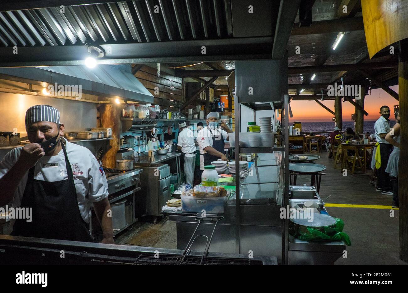Los cocineros en una cocina usan máscaras en un restaurante en Puerto Vallarta, México Foto de stock