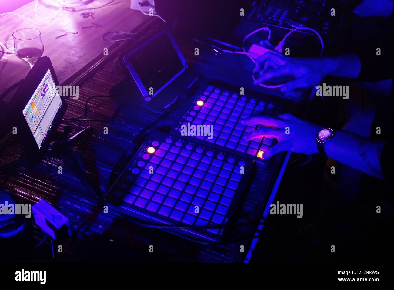 DJ tocando sintetizador y mezclando música en la discoteca. Foto de stock