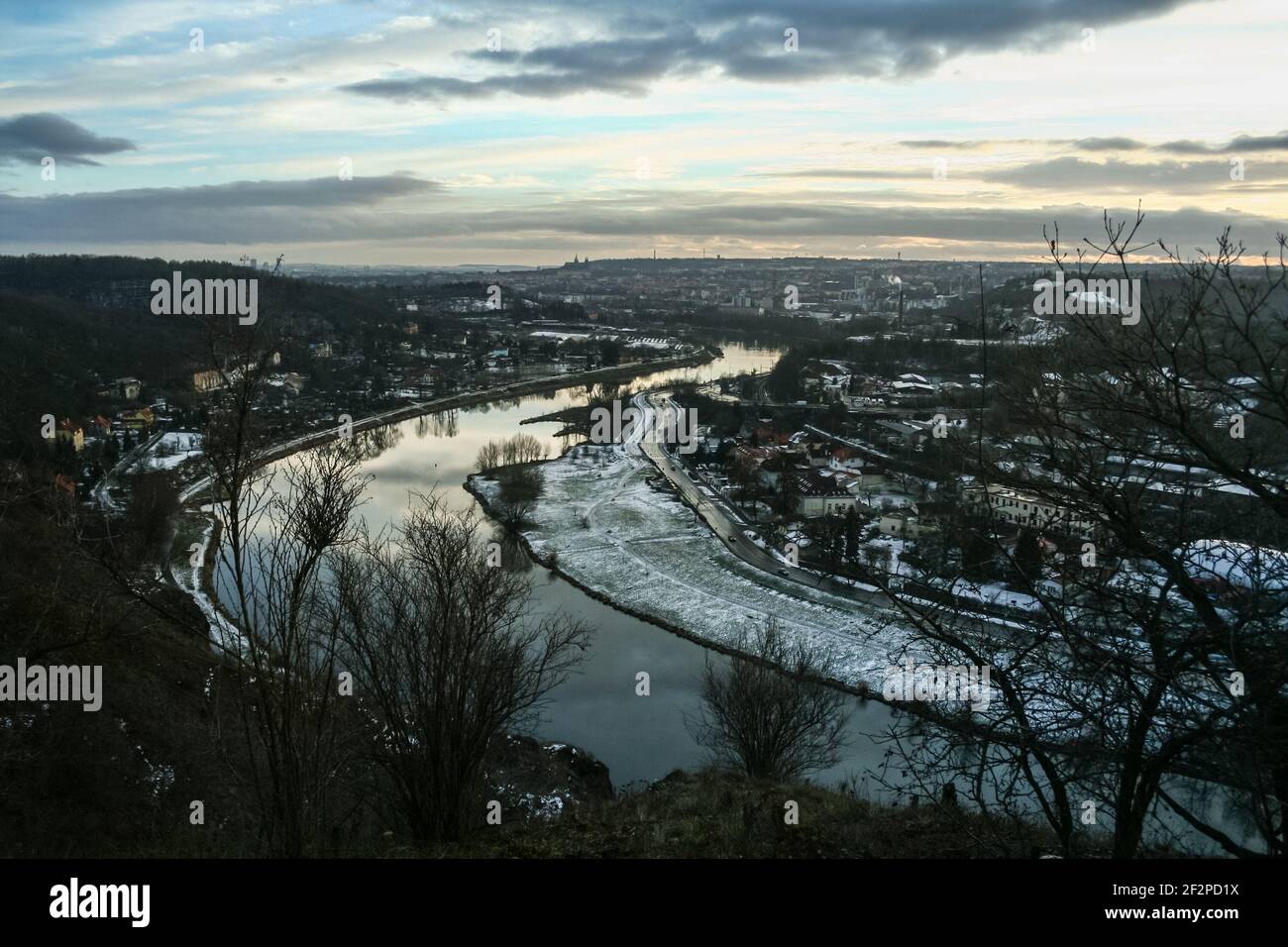 Panorama de praga visto desde arriba desde la colina Zamky, con un enfoque en el río Moldau Vltava y el asentamiento de Sedlec en invierno, al atardecer, en CZ Foto de stock