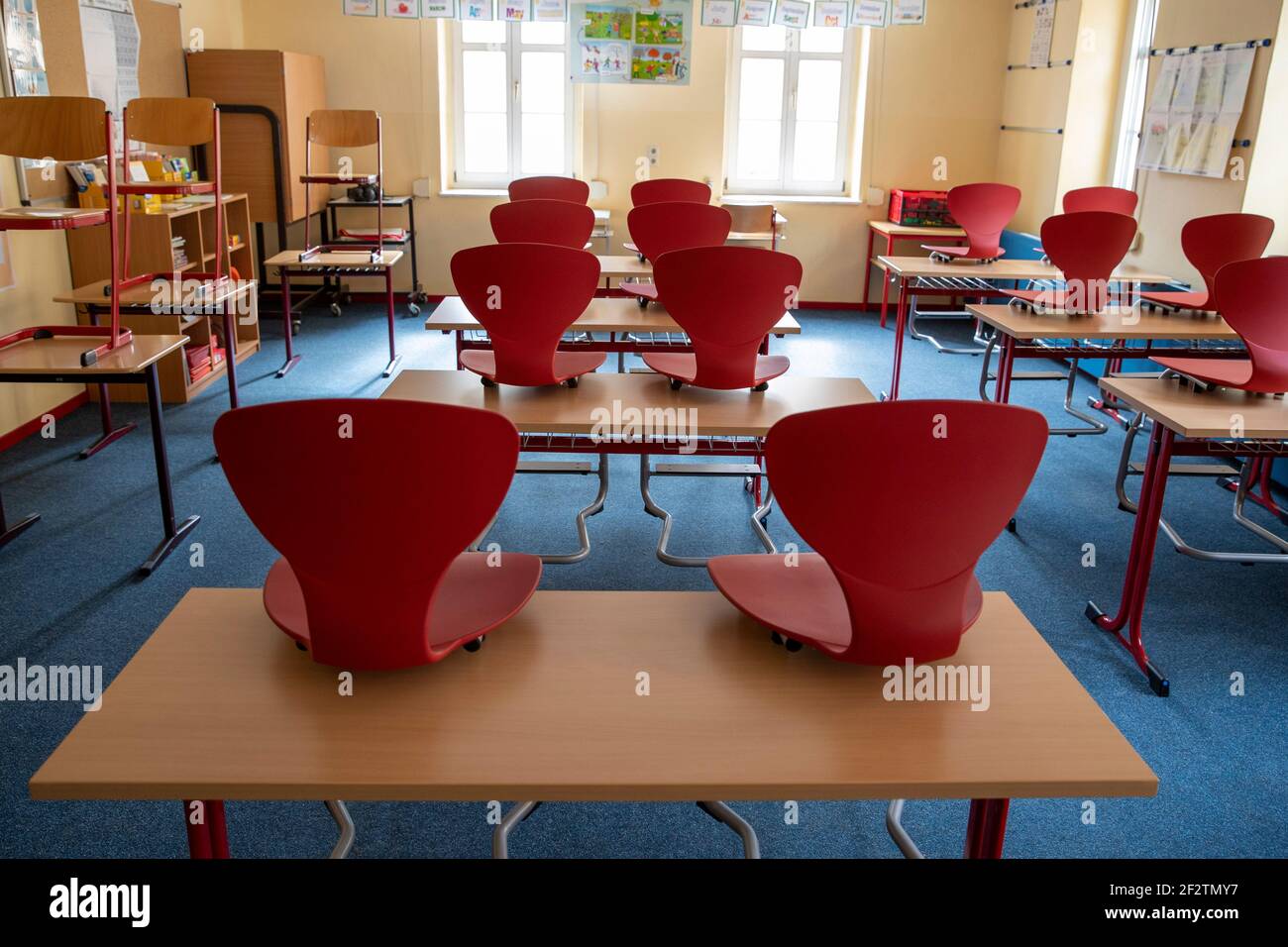 12 de marzo de 2021, Sajonia, Königstein en Sachsen: Varias sillas en un  aula de la escuela primaria de Königstein en Sajonia están de pie sobre la  mesa. Aunque se requiere que