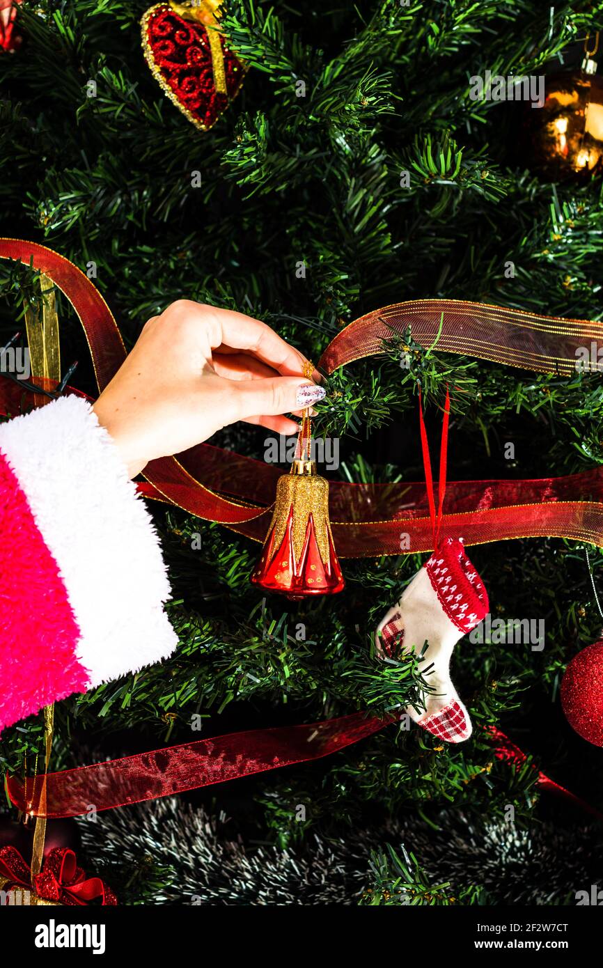 Adornar árbol de Navidad, poner a mano decoraciones de Navidad en ramas de  abeto. Adornos para colgar de Navidad Fotografía de stock - Alamy