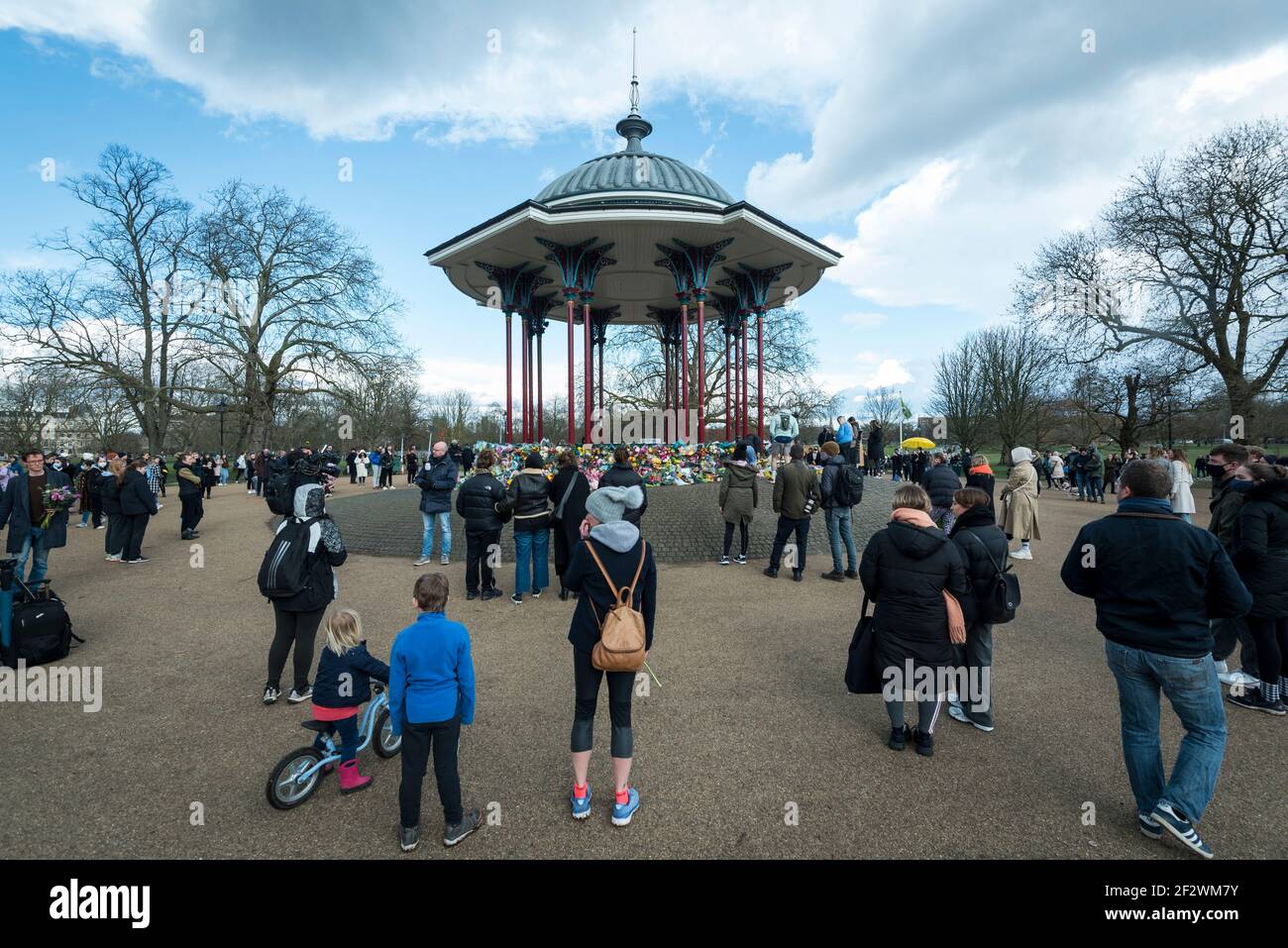 Londres, Reino Unido. 13 de marzo de 2021. La gente ve tributos florales en el quiosco de música de Clapham Common para recordar a Sarah Everard. Wayne Couzens, de 48 años, un oficial de policía de Wet, ha sido acusado de su secuestro y asesinato después de que ella caminara a casa cerca de Clapham Common en el sur de Londres. El cuerpo de la niña de 33 años fue encontrada en los bosques de Kent más de una semana después de que fue avistada por última vez el 3 de marzo. Crédito: Stephen Chung / Alamy Live News Foto de stock