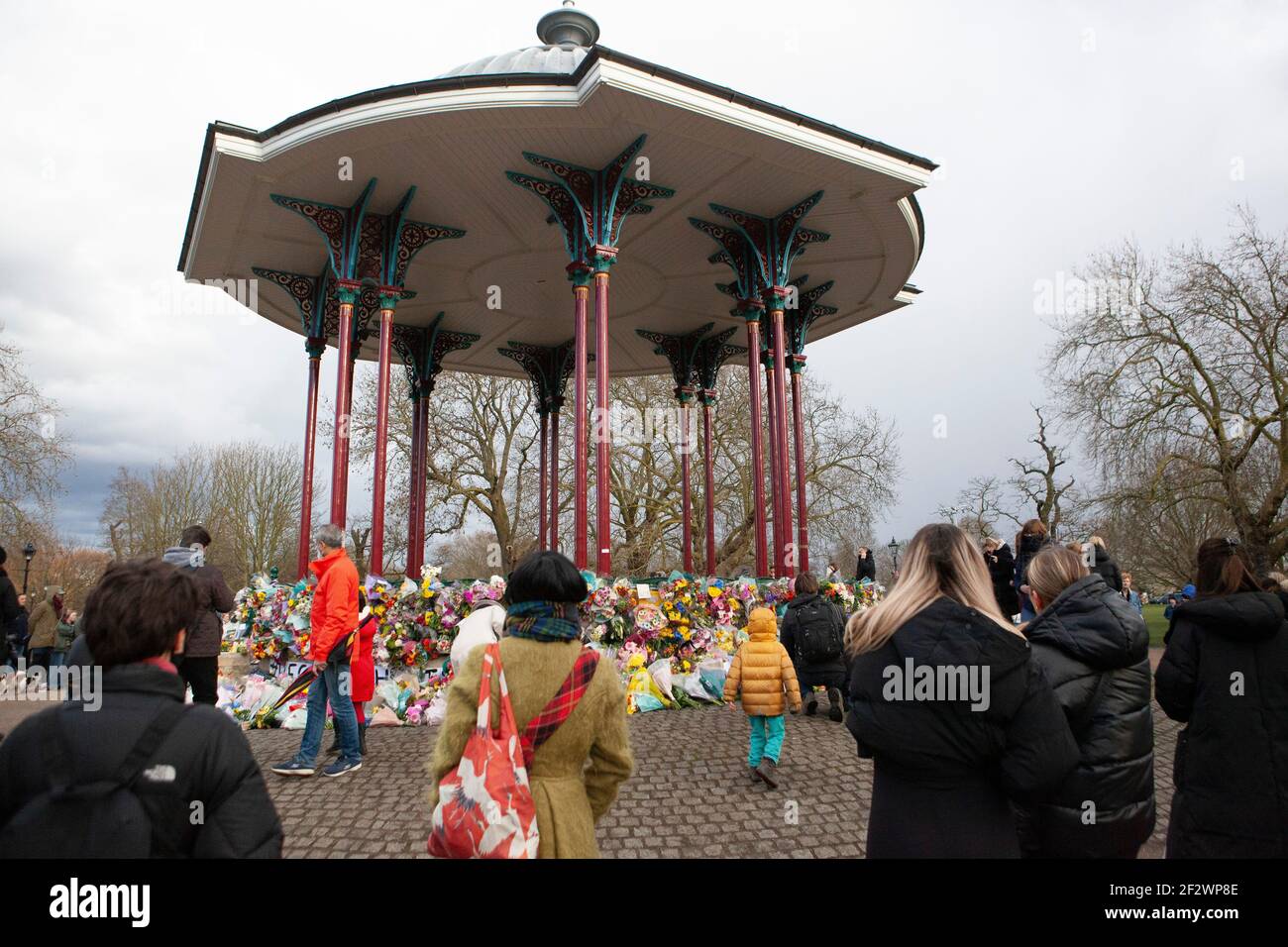 Londres, Reino Unido, 13 de marzo de 2021: Un monumento a las flores de Sarah Everard atrae a cientos de personas que se marchan bien en el bandstand de Clapham Common. Los tributos incluían plantas, flores, velas y mensajes como "¿Cuándo estarán seguras las mujeres?" Y 'solo estaba caminando a casa.' Una vigilia oficial ha sido cancelada debido a las preocupaciones de la policía por el coronavirus. Anna Watson/Alamy Live News Foto de stock