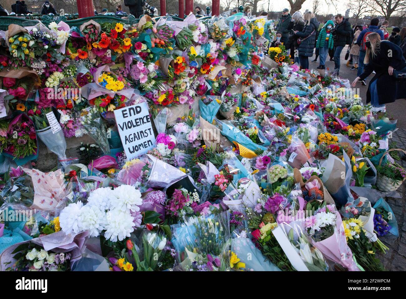 Londres, Reino Unido, 13 de marzo de 2021: Un monumento a las flores de Sarah Everard atrae a cientos de personas que se marchan bien en el bandstand de Clapham Common. Los tributos incluían plantas, flores, velas y mensajes como "¿Cuándo estarán seguras las mujeres?" Y 'solo estaba caminando a casa.' Una vigilia oficial ha sido cancelada debido a las preocupaciones de la policía por el coronavirus. Anna Watson/Alamy Live News Foto de stock