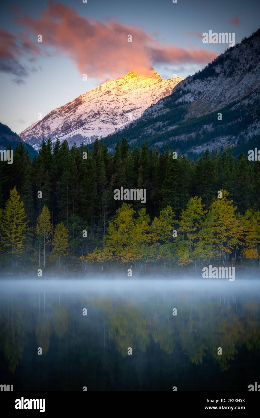 Alpenglow calentando el pico de esta montaña en Wedge Pond al amanecer durante una mañana de septiembre. Foto de stock