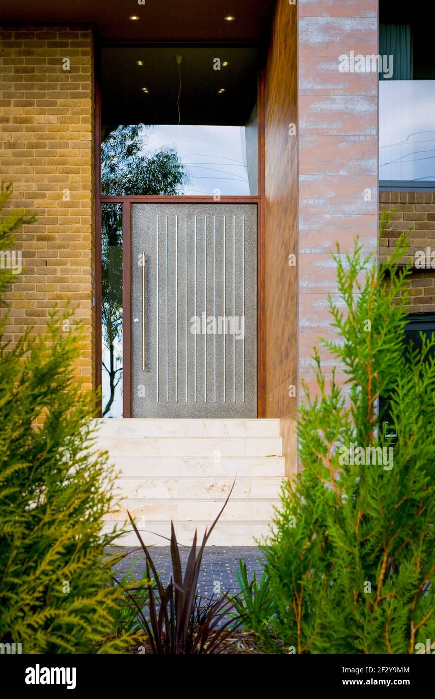Puerta principal de casa moderna con coníferas Fotografía de stock - Alamy