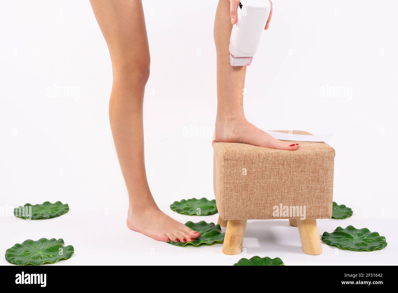Eliminación del vello. Ajuste a la mujer joven encerando sus piernas con un  calentador de cera depilatorio de rodillo portátil para indoloro. Producto  para el cuidado de la piel, salud femenina y