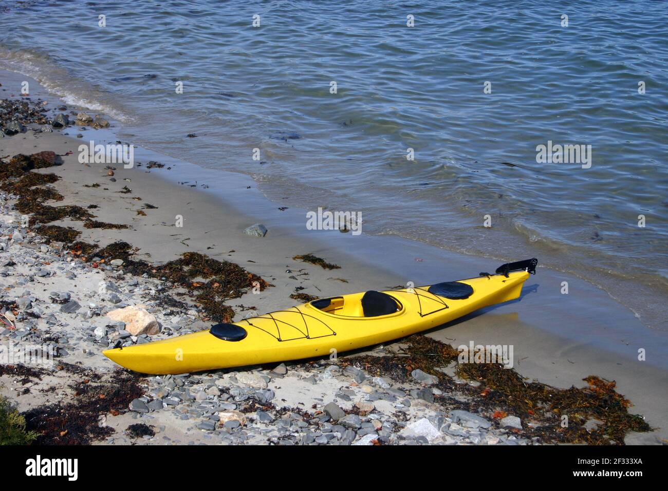 Kayak amarillo vacío y esperando a ser sacado para una aventura, Maine, EE.UU. Foto de stock