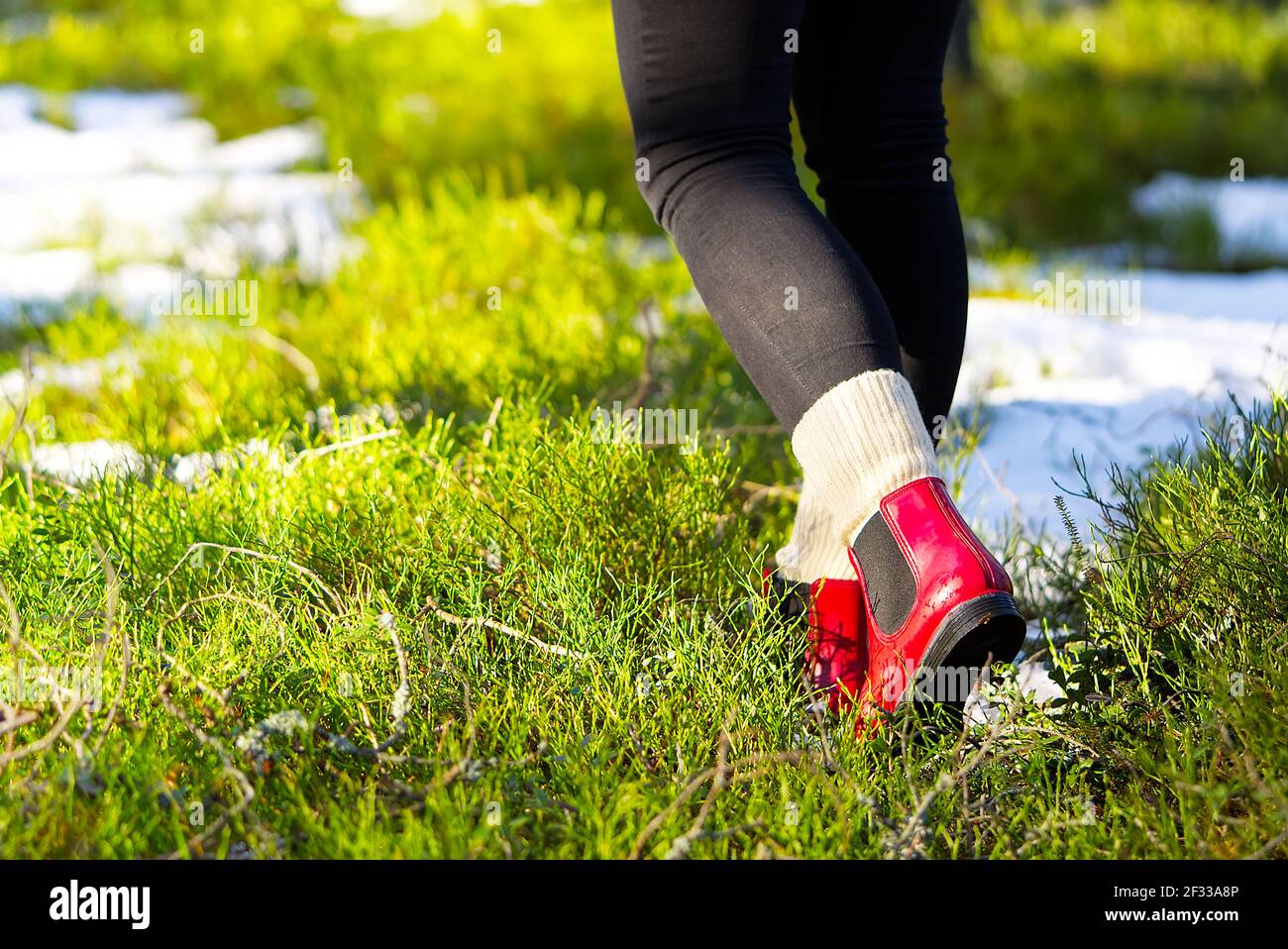 Concepto de otoño o primavera con bosque colorido y botas de lluvia fuera.  Primer plano de los pies de la mujer caminando con botas rojas Fotografía  de stock - Alamy